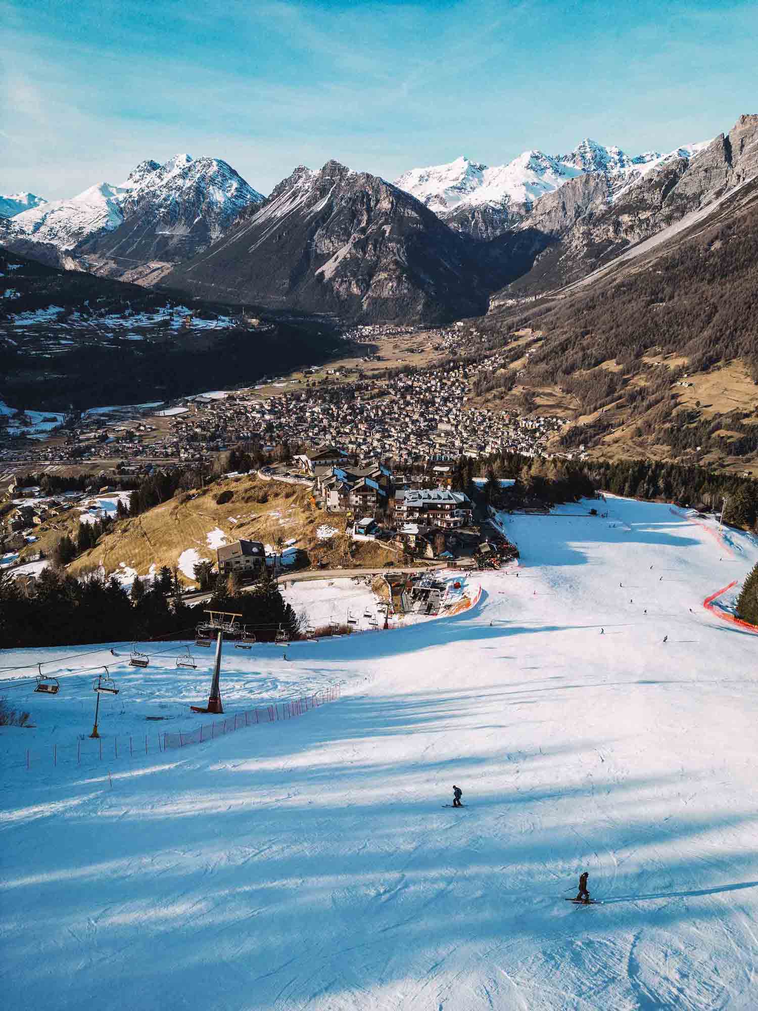 Skiers descending along a ski slope in Bormio