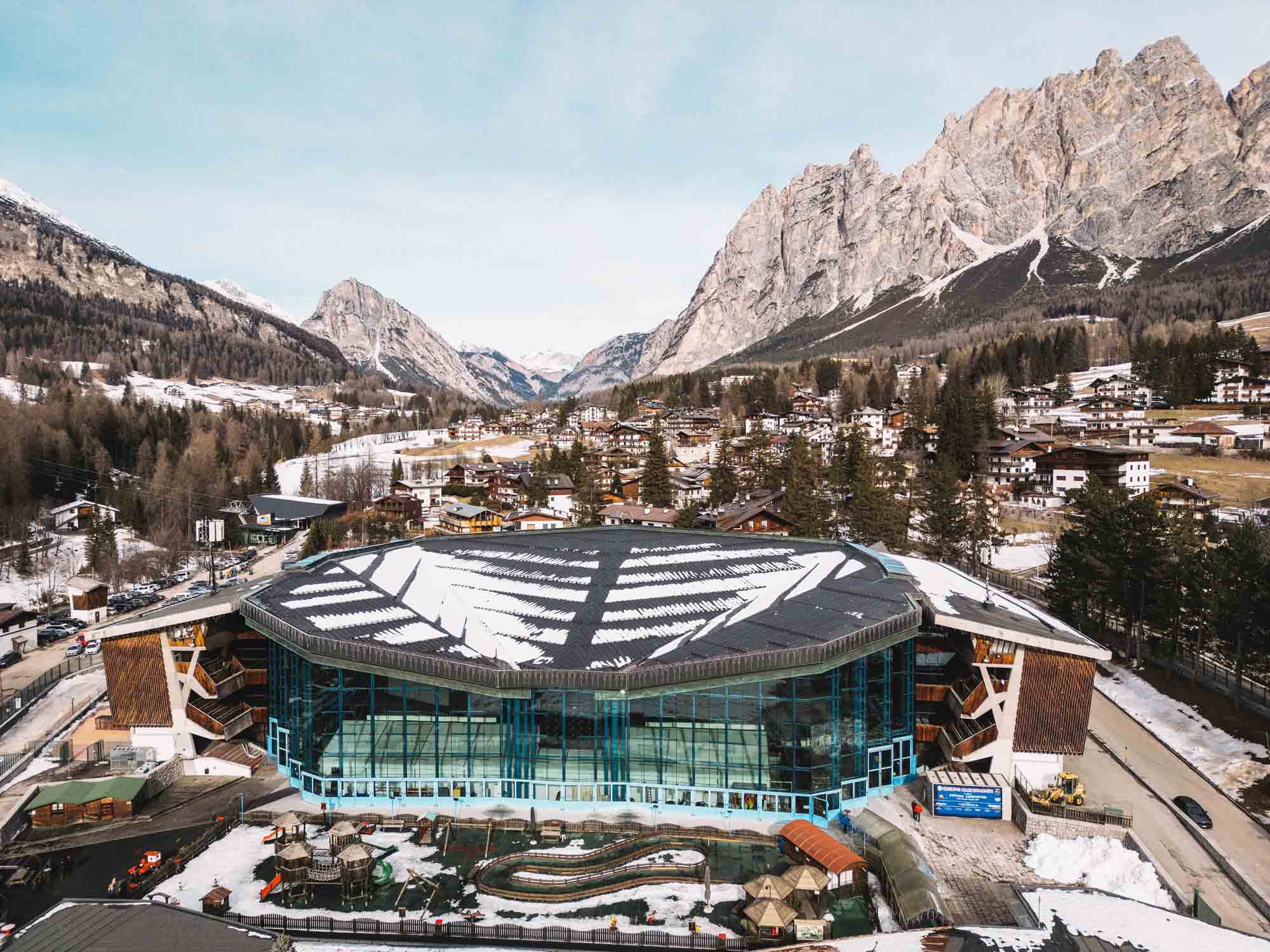 a snow-covered aerial view of the Olympic Curling Stadium in Cortina