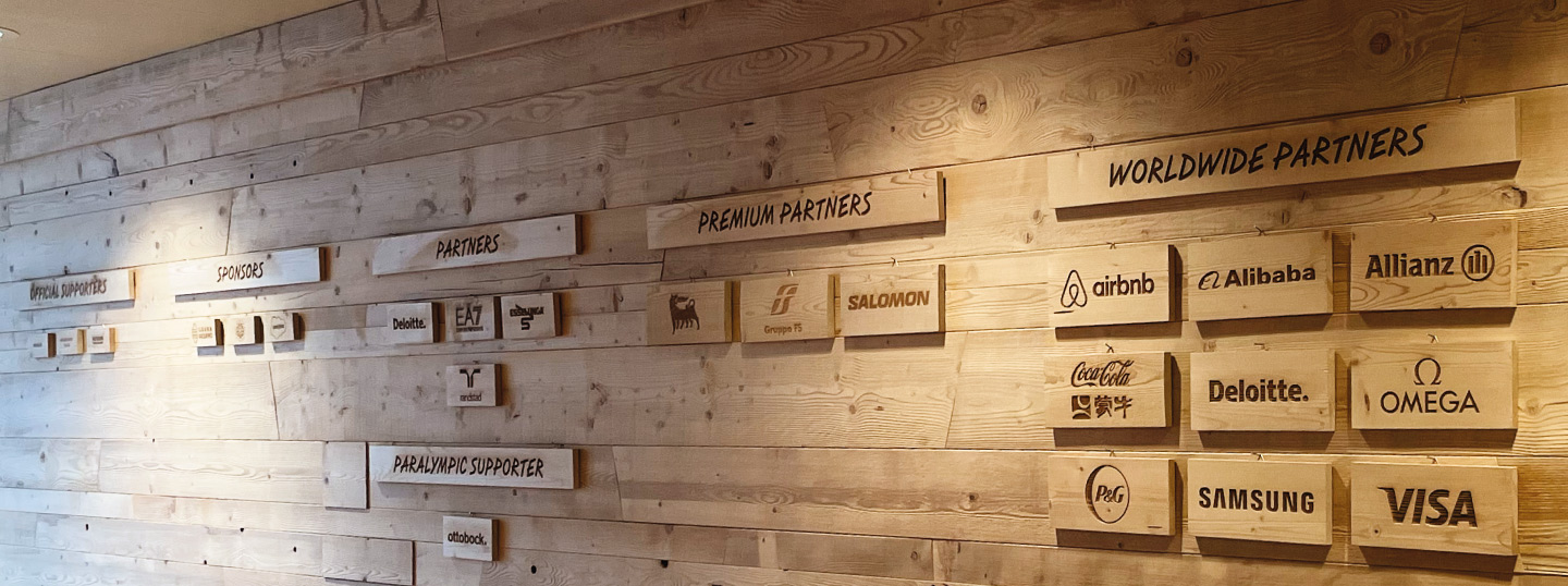 eine Holzwand mit verschiedenen Logos darauf