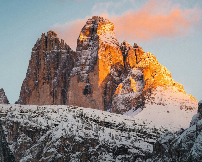 una montagna coperta di neve è illuminata dal sole