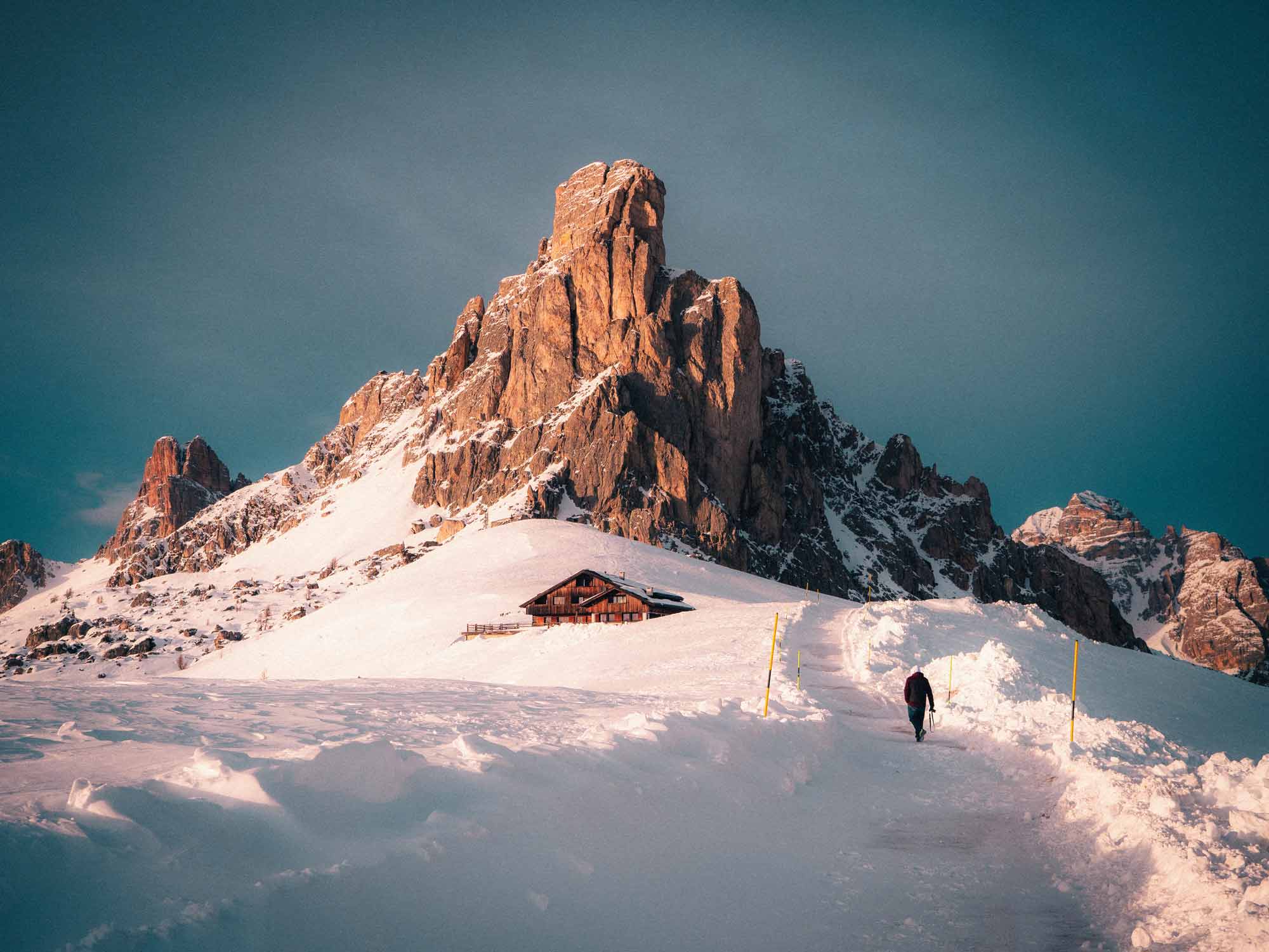 Individual hiking along a snowy mountain trail in Cortina d'Ampezzo