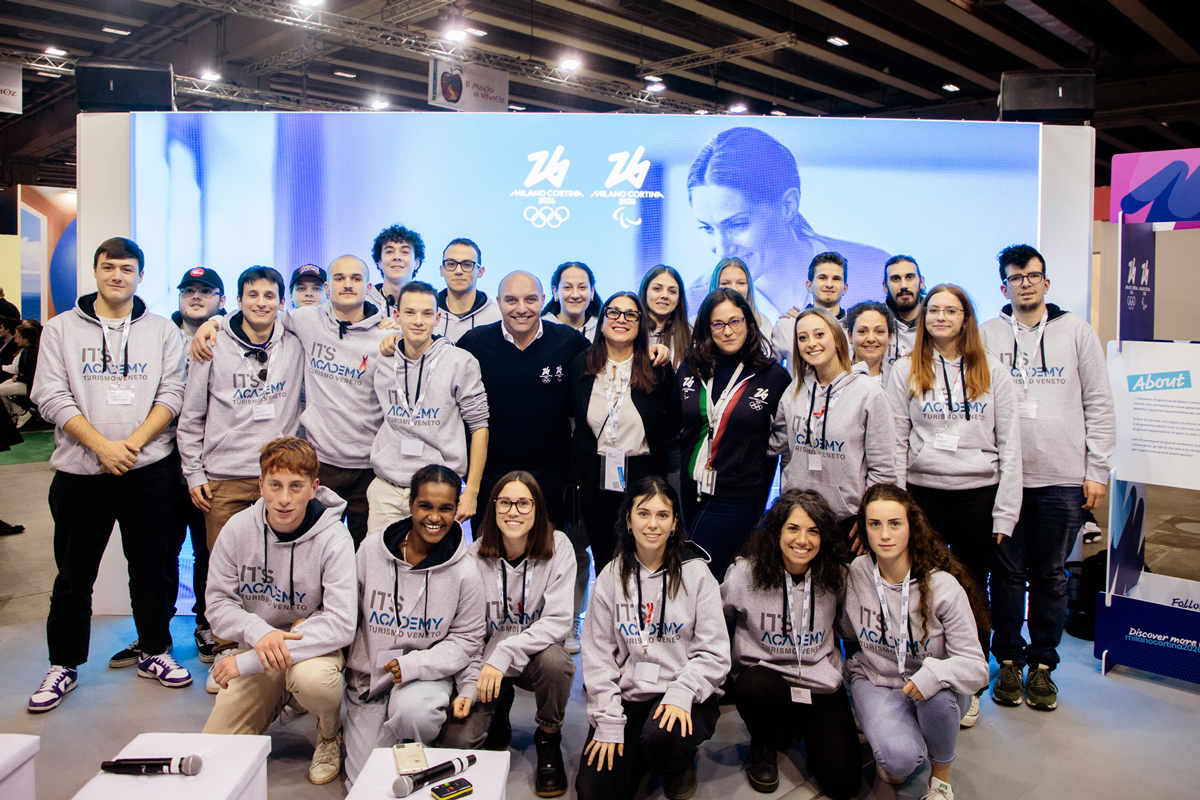 Group photo with boys and girls wearing a 'its academy' sweatshirt with some members of the Milan Cortina 2026 Foundation
