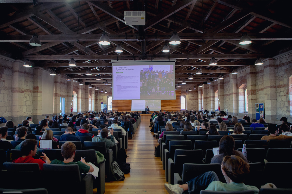 sala conferenze con un pubblico seduto che assiste a una presentazione