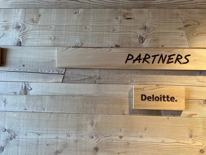 Foto della parete dei partner con targhetta Deloitte