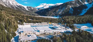 Aerial view of Anterselva surrounded by trees and snow-capped mountains