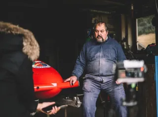 Foto di Diego Menardi seduto, con a fianco un bob.