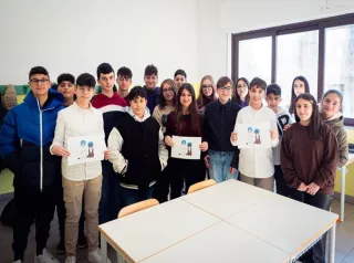 Foto di una classe di bambini con dei disegni in mano