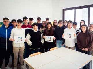 Foto di una classe di bambini con dei disegni in mano