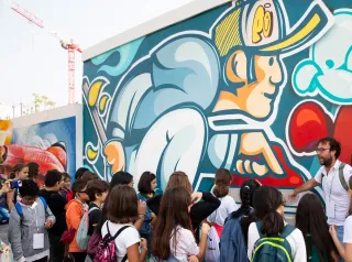 Foto di un gruppo di bambini mentre guardano il murales