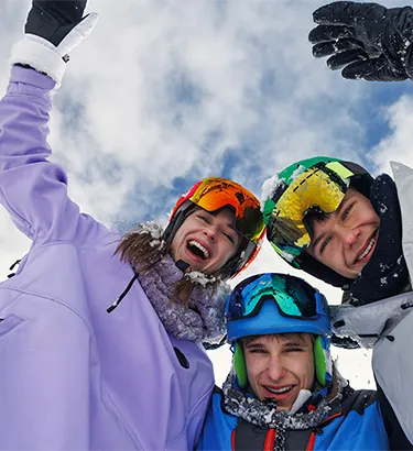 Kinder in Winterbekleidung, die von oben in die Kamera winken